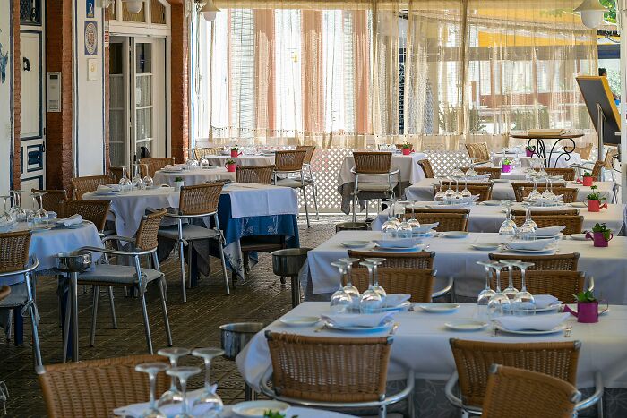 Outdoor European restaurant with neatly arranged tables and chairs, illustrating European netizens correcting common country facts.