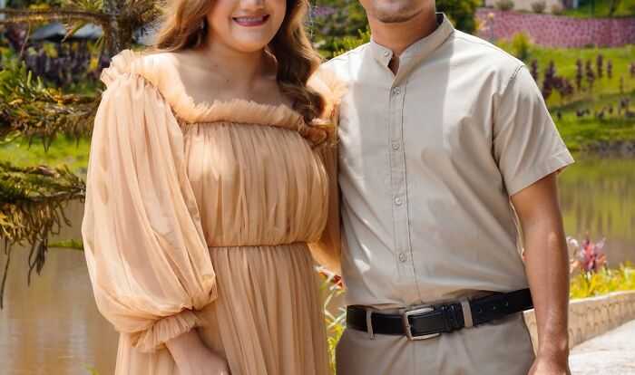 Couple standing outdoors by a pond, dressed in neutral tones, representing secrets people would rather not confess to partners.