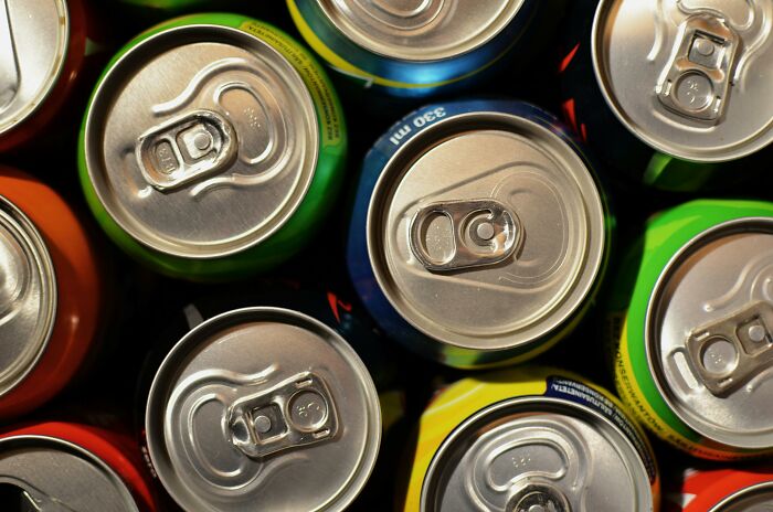 Top view of various unopened soda cans representing casual and harmless looking habits that may cause damage long term