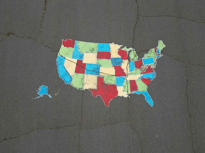Map of the United States painted on pavement with states in different colors representing spelling challenge data.