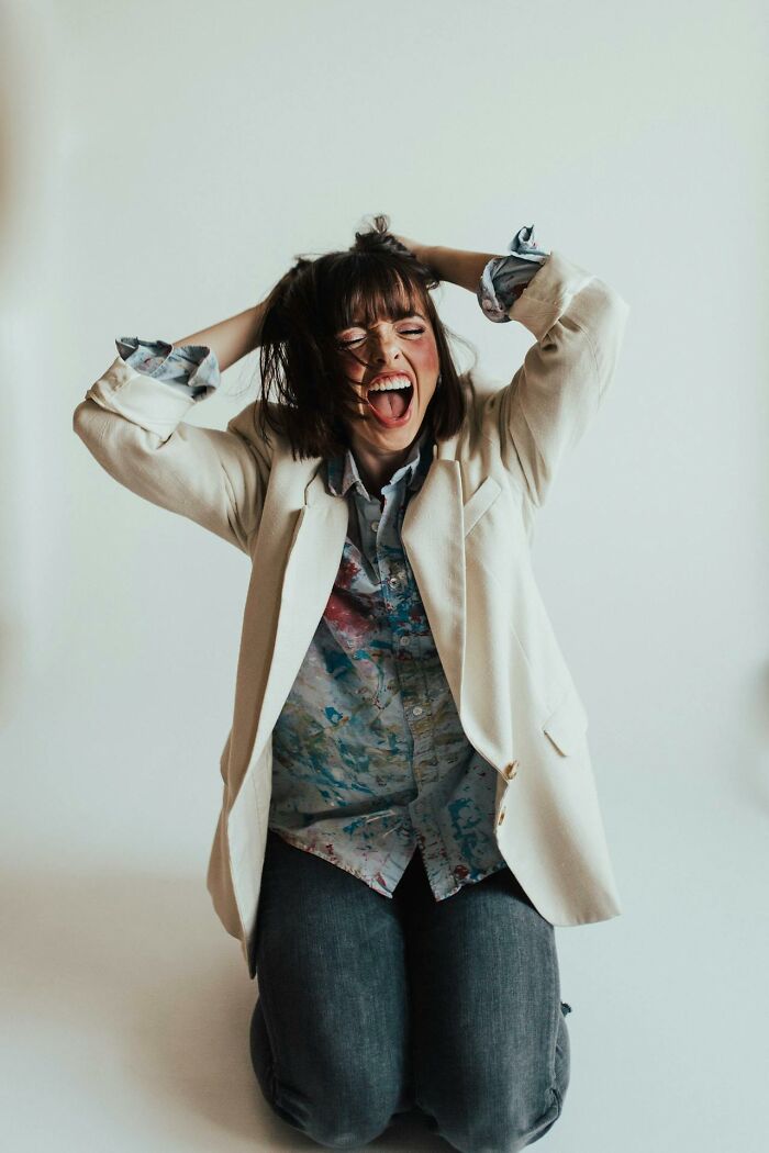 Young woman kneeling with hands in hair, expressing frustration, illustrating emotions linked to worst parents experiences.