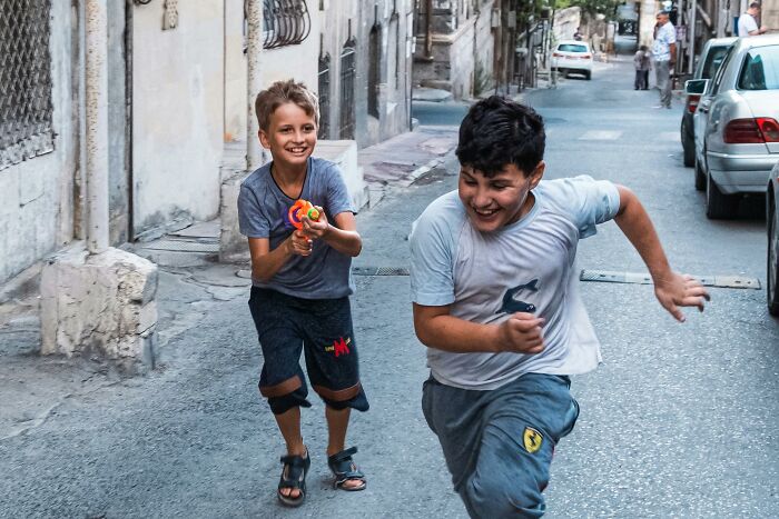 Two boys playing on a narrow street, capturing candid moments reflecting honest views about the UK and everyday life.