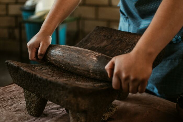 Person using a traditional historical tool, highlighting expertise in identifying old tools in a historian quiz. Person using a traditional historical tool, highlighting expertise in identifying old tools in a historian quiz.