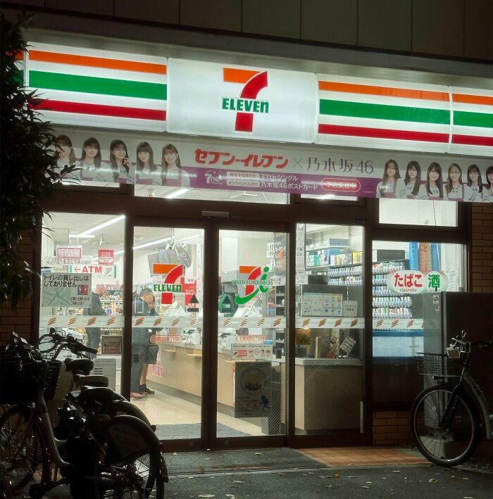 7-Eleven convenience store entrance at night with bright signage and bicycles outside, highlighting completely legal total psychopath.