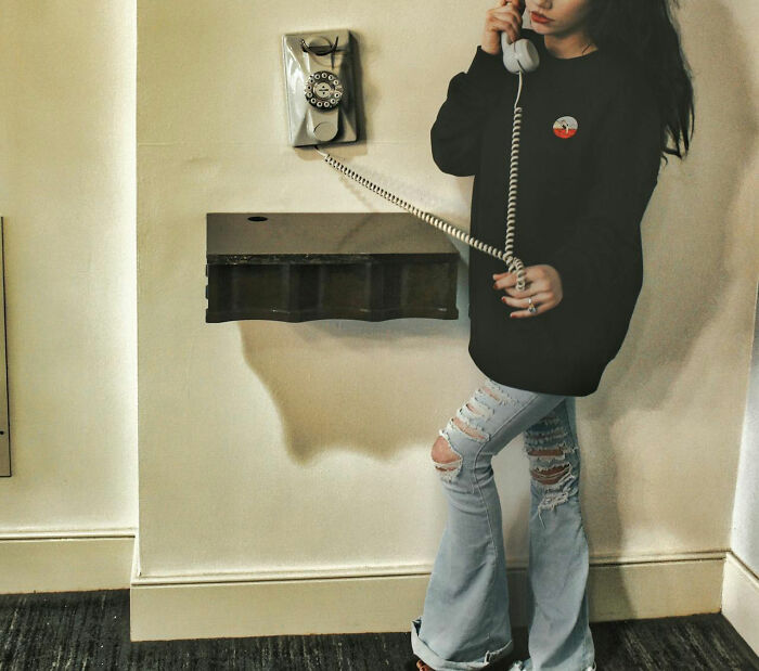 Young woman using a vintage rotary phone, capturing the unique childhood joys that faded with smartphones.