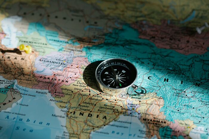 Compass placed on a detailed map highlighting countries in Asia for geography and word puzzles anagram challenge quiz.