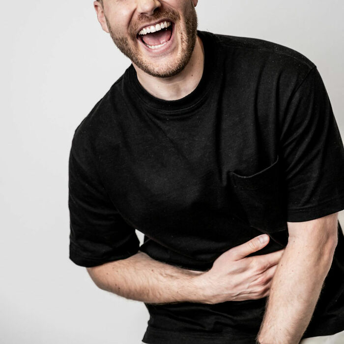 Man in black shirt laughing, representing a private resort worker during an ask me anything session with answers.