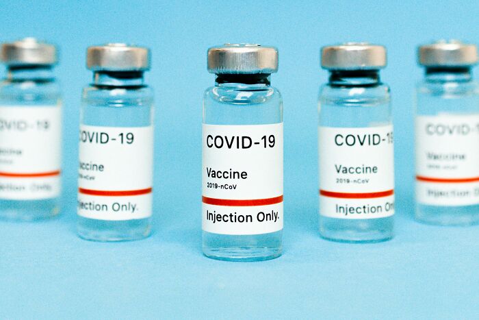 Vials of COVID-19 vaccine on a blue surface representing fictional things people are still falling for.
