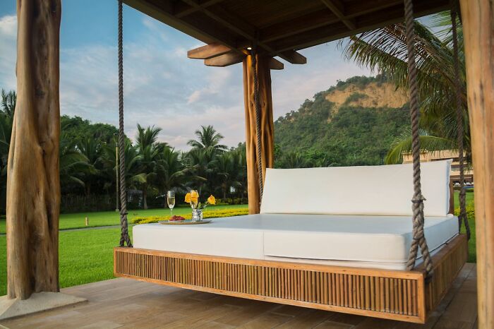 Outdoor private resort relaxation area with a hanging daybed and drinks, perfect for a resort worker’s break.