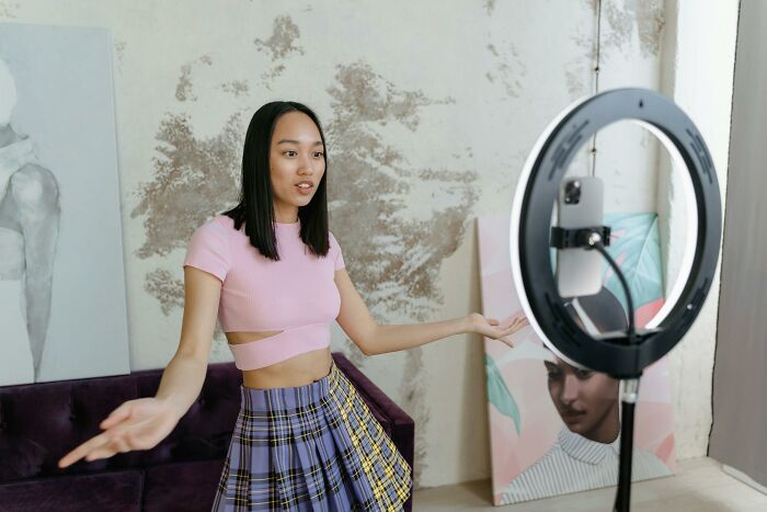 Young woman sharing hobbies on camera with ring light setup, illustrating hobbies that give netizens the ick quickly