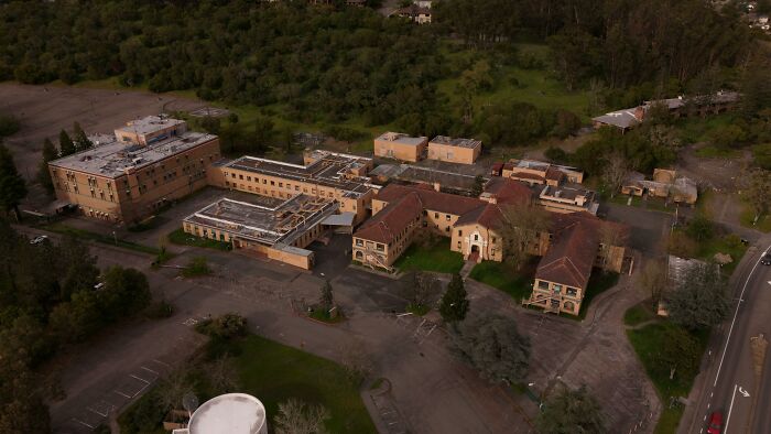 Aerial view of an abandoned complex surrounded by trees, linked to explorers encountering creepy things during escapades.