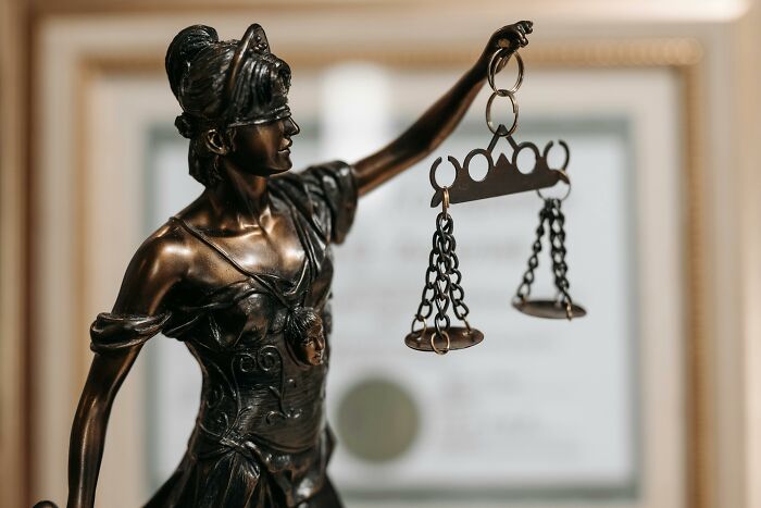 Bronze statue of Lady Justice holding scales, symbolizing fictional things that were never real to begin with.