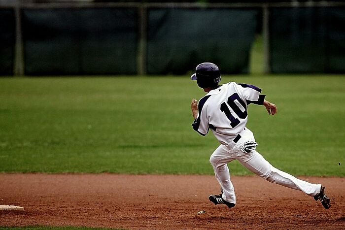 Young baseball player wearing number 10 running on the field, representing one wrong deed changing a life story.