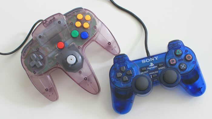 Two translucent wired game controllers side by side, representing a good trend slowly disappeared in gaming technology.