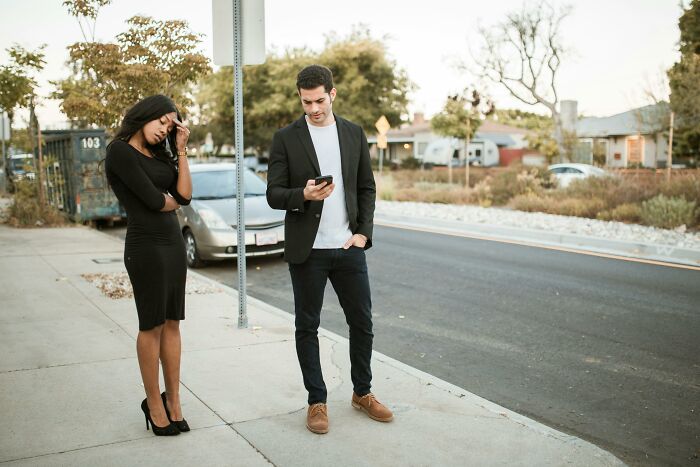 Couple standing on sidewalk looking upset, illustrating hobbies that give netizens the ick faster than a bad date.