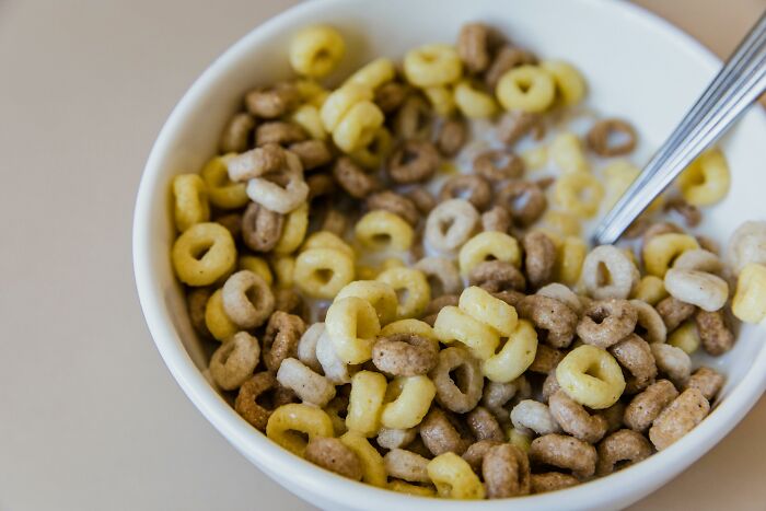 Bowl of multicolored cereal with milk and a spoon, illustrating things non-Americans do like breaking spaghetti.