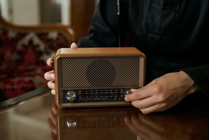 Person adjusting knobs on a vintage radio, illustrating a completely normal thing causing irrational ick feelings.