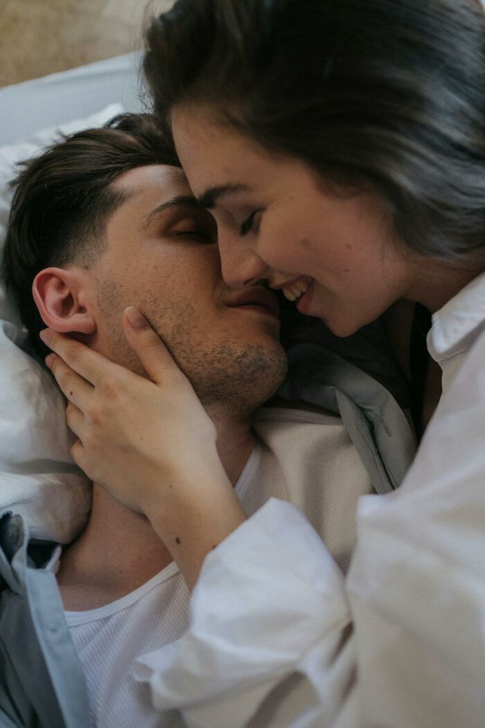 Couple sharing an intimate moment in bed, illustrating themes from women sharing wildest things they let exes get away with.