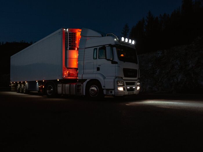 White semi truck parked at night with headlights on, capturing a creepy and scary moment from truck drivers’ lives.