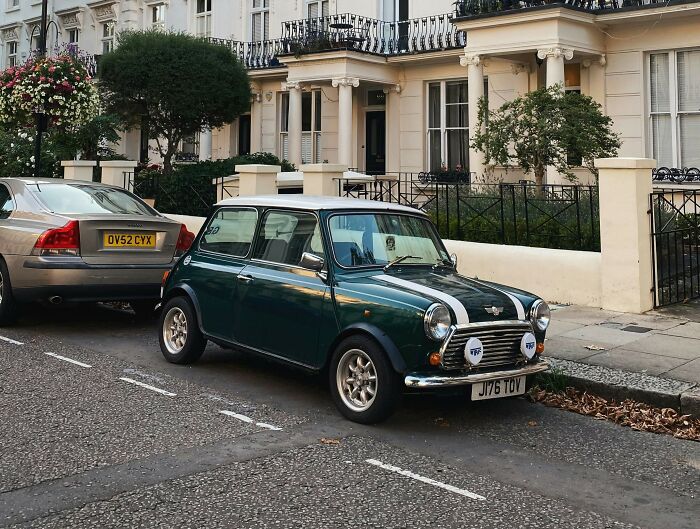Classic Mini Cooper parked on a London street, showcasing iconic UK car culture and urban neighborhood charm.