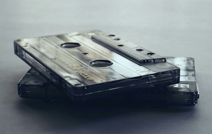 Stack of clear cassette tapes on a gray surface representing 90s icon nostalgia for a fun quiz about soulmates.