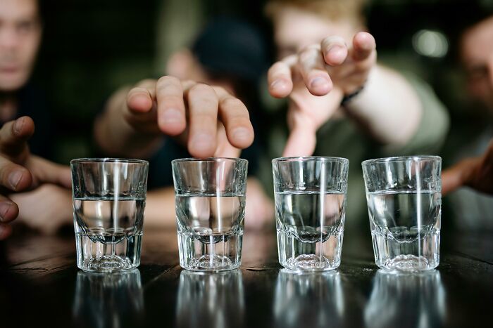 Several people reaching for clear glasses filled with water, illustrating things people thought everyone knew.