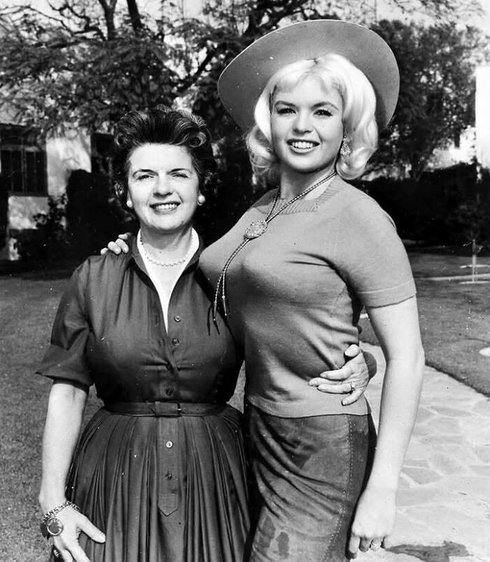 Two women smiling outdoors in a timeless black and white photo showing what the past looked like.