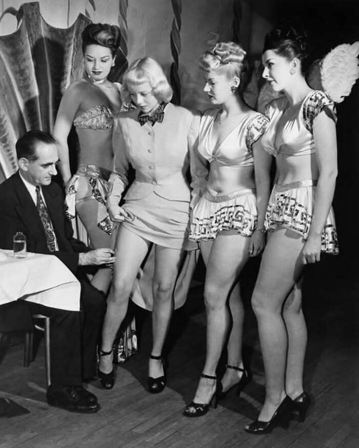 Grupo de mujeres en ropa de época, mostrando un lado distinto de la historia en una escena curiosa y vintage.