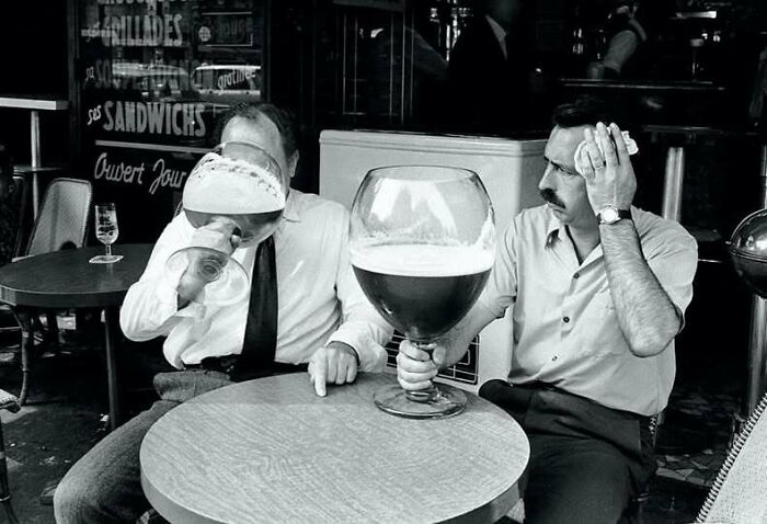 Hombres en cafetería con copas gigantes de cerveza en foto histórica que muestra un lado distinto de la Historia.
