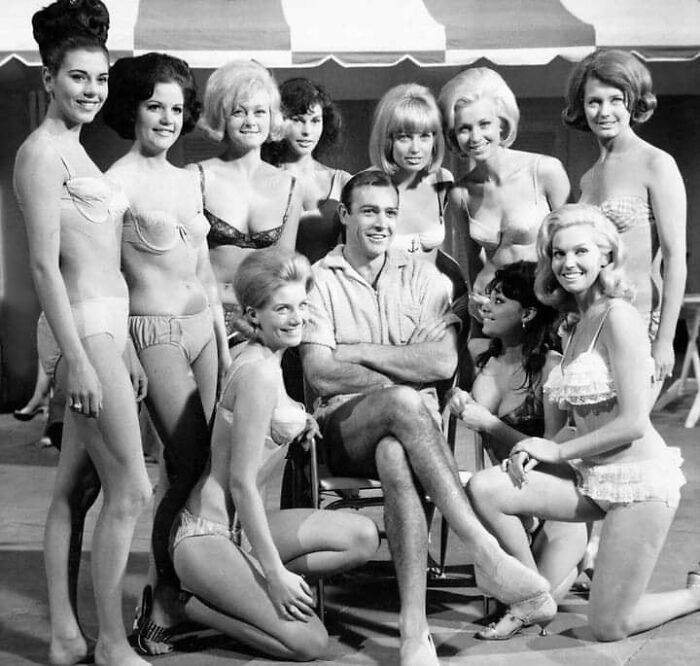 Group of men and women in vintage swimwear posing together in a timeless photo showing what the past looked like.