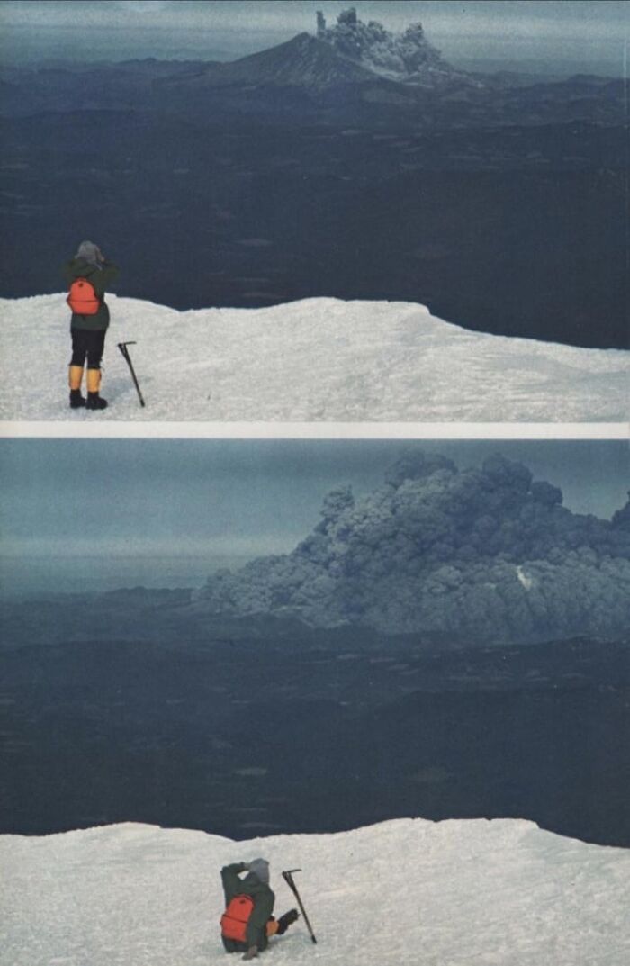 Hiker with an orange backpack capturing alternative angles of an active volcano erupting with unseen ash clouds.