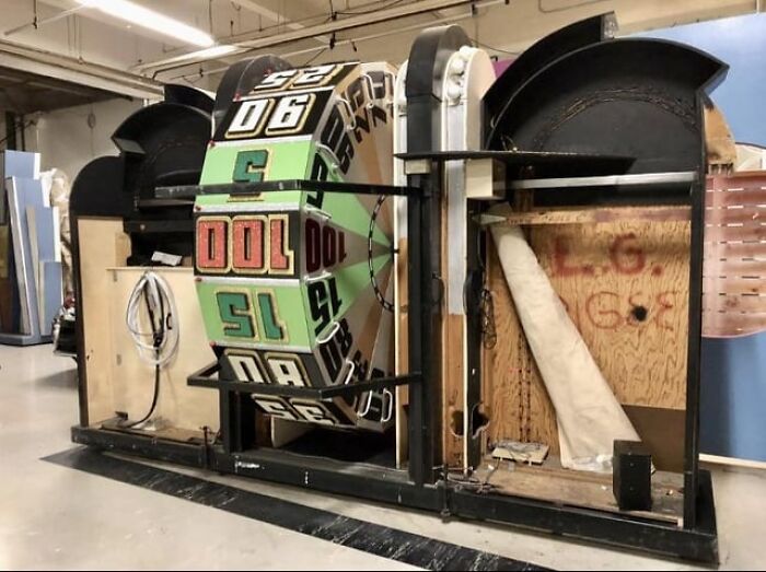 Large vintage spinning wheel game showing alternative angles of unseen sections in a workshop setting.