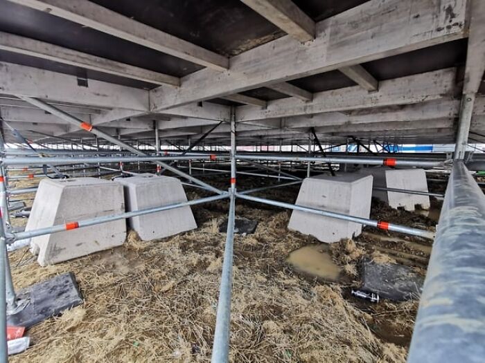 Support structure under a large platform showing alternative angles of metal scaffolding and concrete blocks unseen.