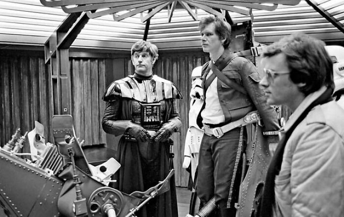 Behind-the-scenes photo showing alternative angles of actors in sci-fi costumes on a set with futuristic equipment.