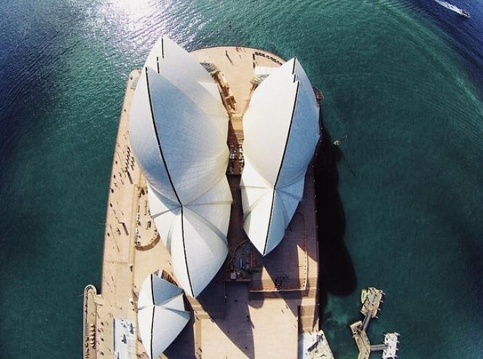 Aerial view of Sydney Opera House showing alternative angles and unseen architectural details by the water.
