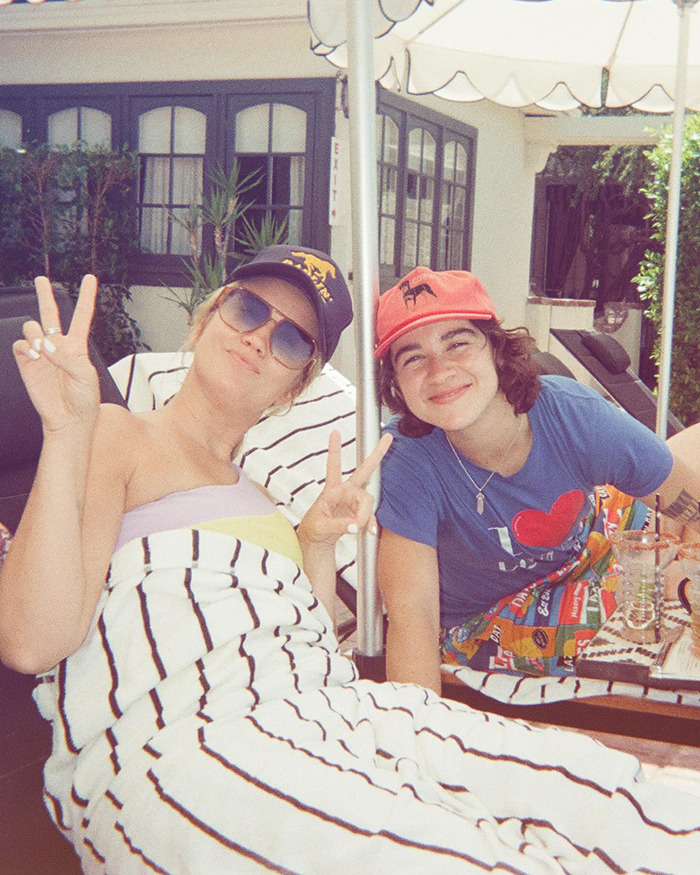 Pitch Perfect star with girlfriend relaxing outdoors, showing peace signs while defending 18-year age gap in a statement.