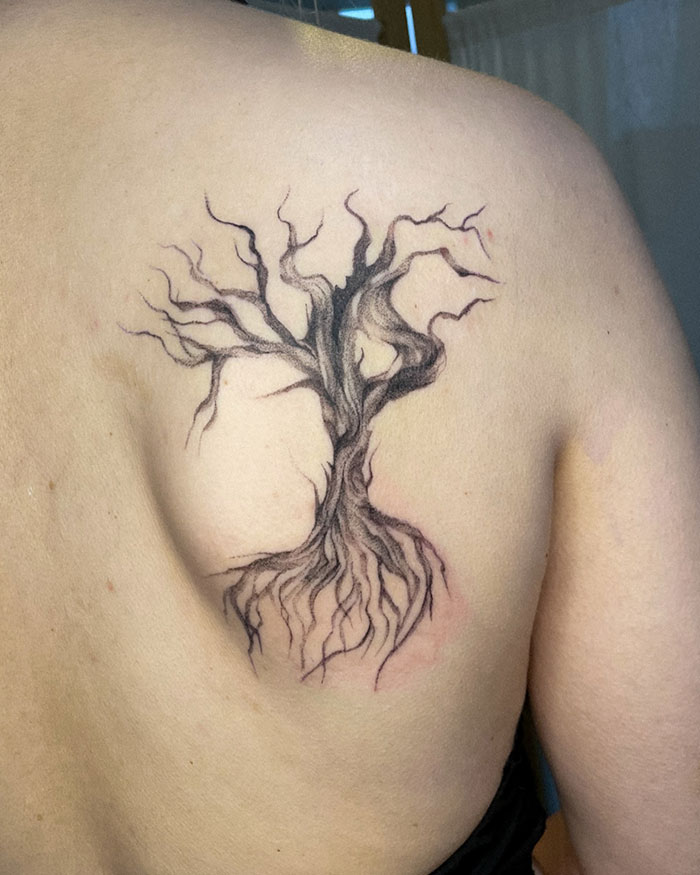 Poison tree tattoo on upper back featuring twisted branches and exposed roots in black ink style Poison tree tattoo on upper back featuring twisted branches and exposed roots in black ink style