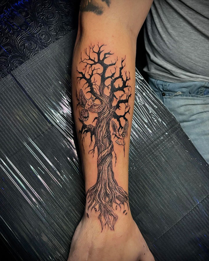 Forearm tattoo of a poison tree with detailed twisted branches and birds, showcasing unique styles and symbolism. Forearm tattoo of a poison tree with detailed twisted branches and birds, showcasing unique styles and symbolism.