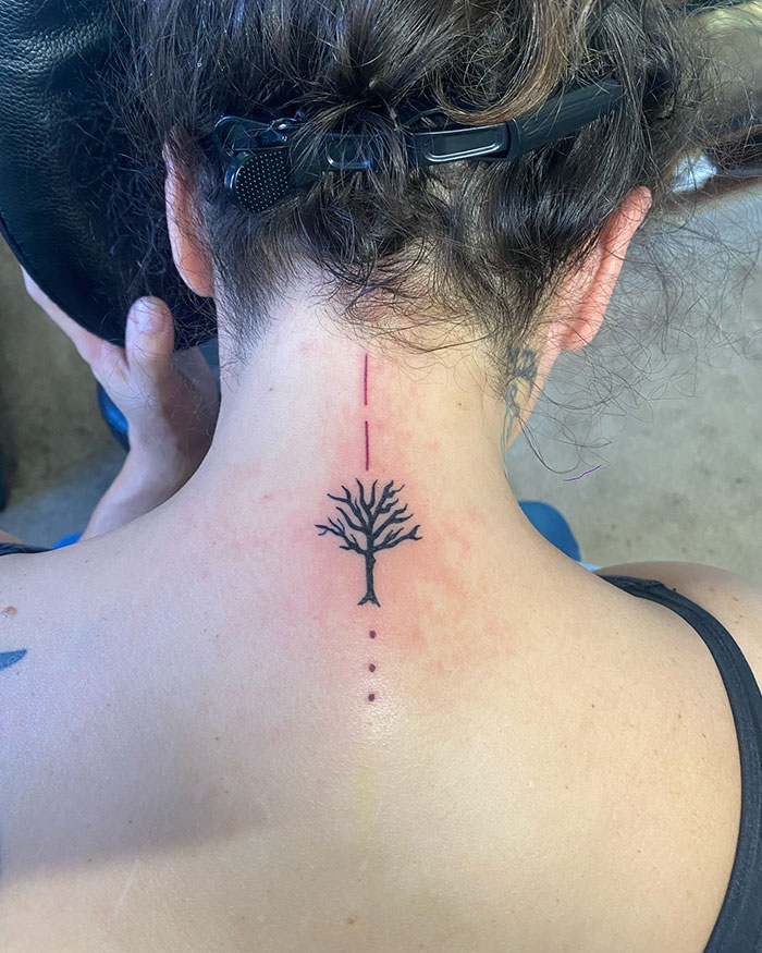 Minimalist poison tree tattoo on the nape of the neck with linear dot and dash design on fair skin. Minimalist poison tree tattoo on the nape of the neck with linear dot and dash design on fair skin.