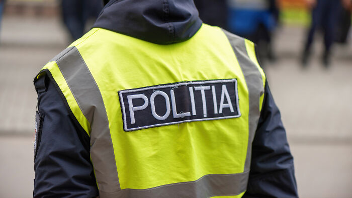 Police officer wearing a reflective vest with politia text, illustrating something normal in other countries that shocks Americans