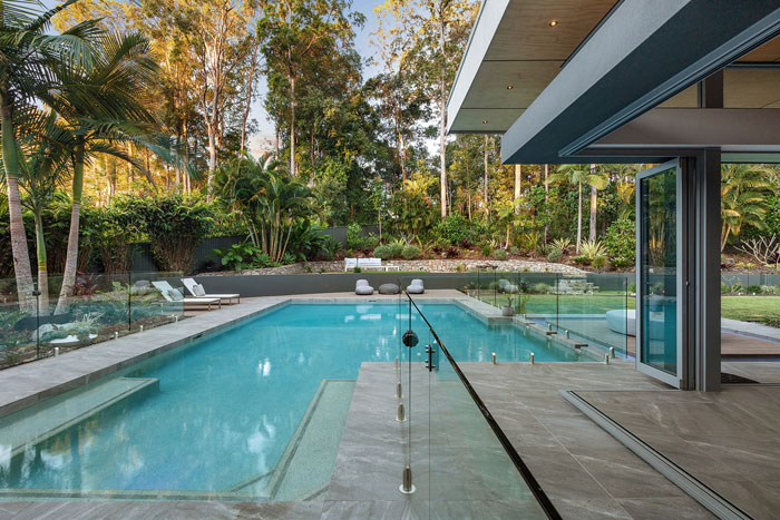 Modern backyard pool with glass fence highlighting kids safety concerns and partner&rsquo;s ignored requests.