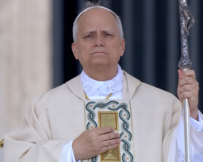 Pope Leo XIV holding a staff and religious book, representing nepopetism in a formal religious ceremony.