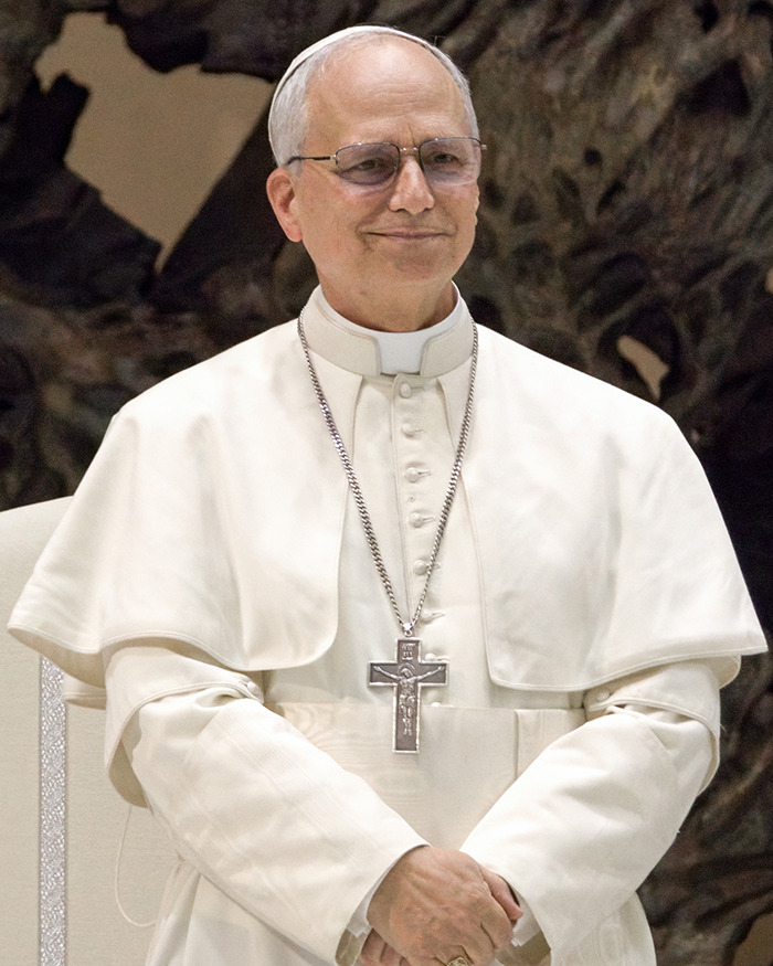 Pope Leo XIV smiling in white papal robes and glasses, related to nepopeptism news and reactions.