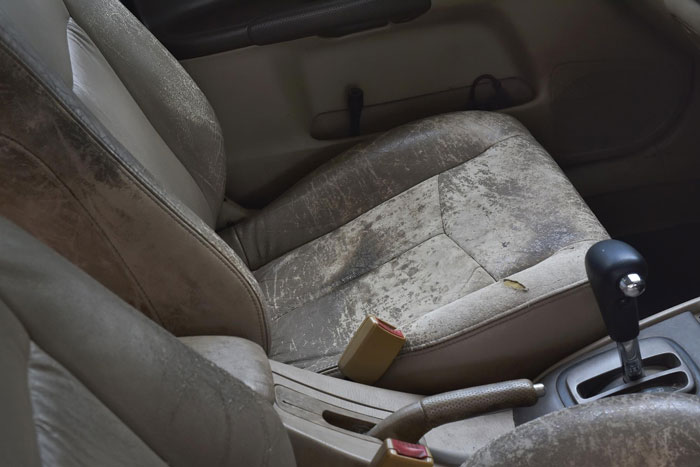 Interior of a worn Porsche car showing dirty seats and gear shift, related to parking across handicap spots incident.