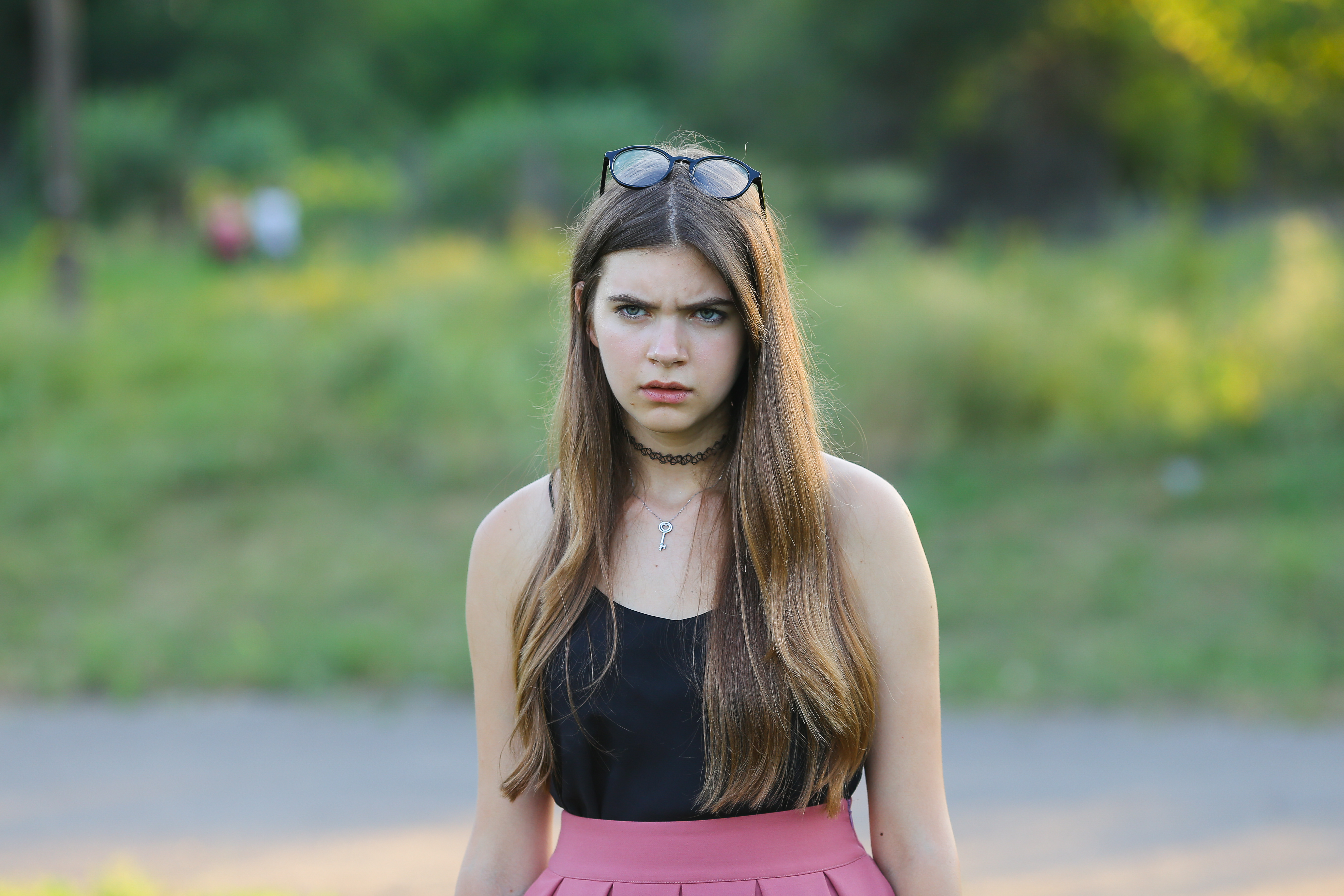 Young woman looking angry outdoors, expressing frustration about sibling refusing to babysit child all summer for free