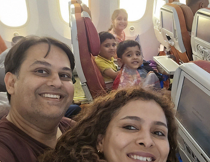 Family taking a final moment captured photo inside Air India plane before the disaster occurred, smiling and seated together.
