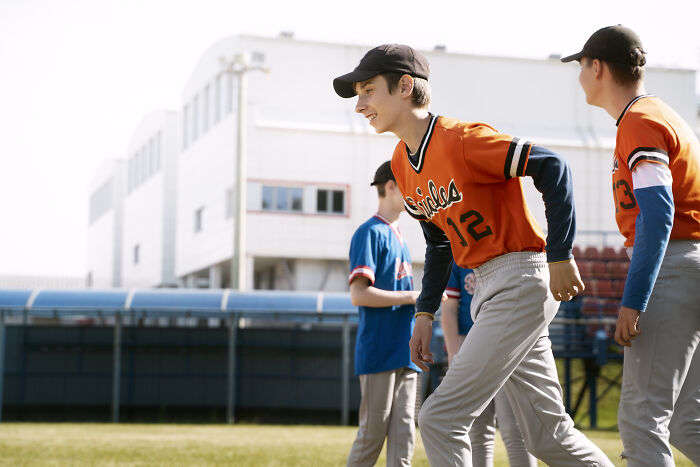 Teen boys in baseball uniforms playing on a field, illustrating rich kid meltdowns at private schools stories.