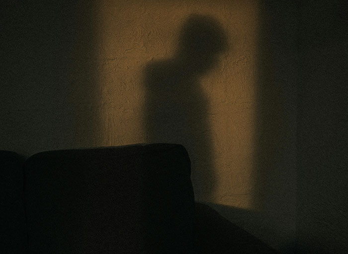 Shadow of a person cast on a textured wall, symbolizing the unsettling patients who genuinely scared psychologists.