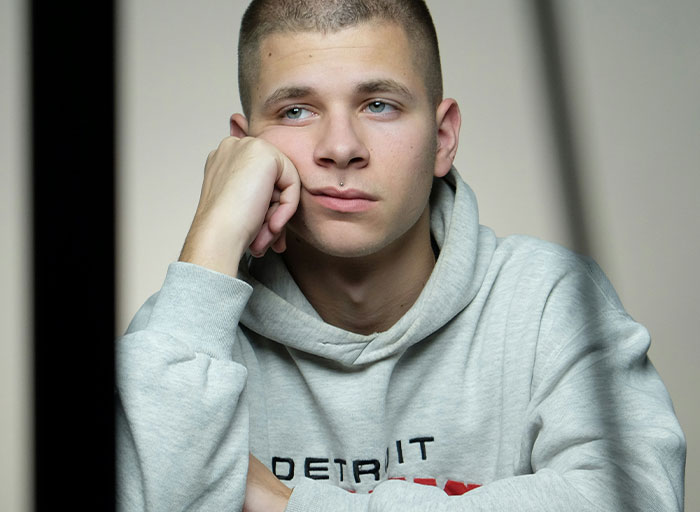 Young man in a gray hoodie looking thoughtful and concerned, illustrating psychologists discussing patients who scared them.