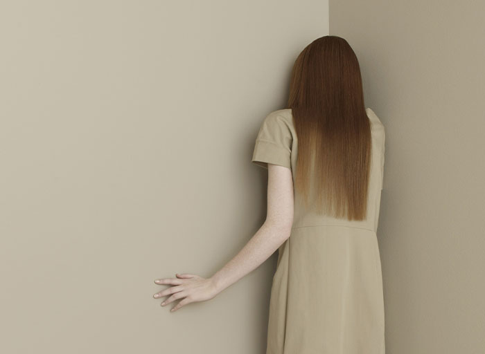 Woman with long hair facing a corner, illustrating the fear experienced by psychologists with certain patients.